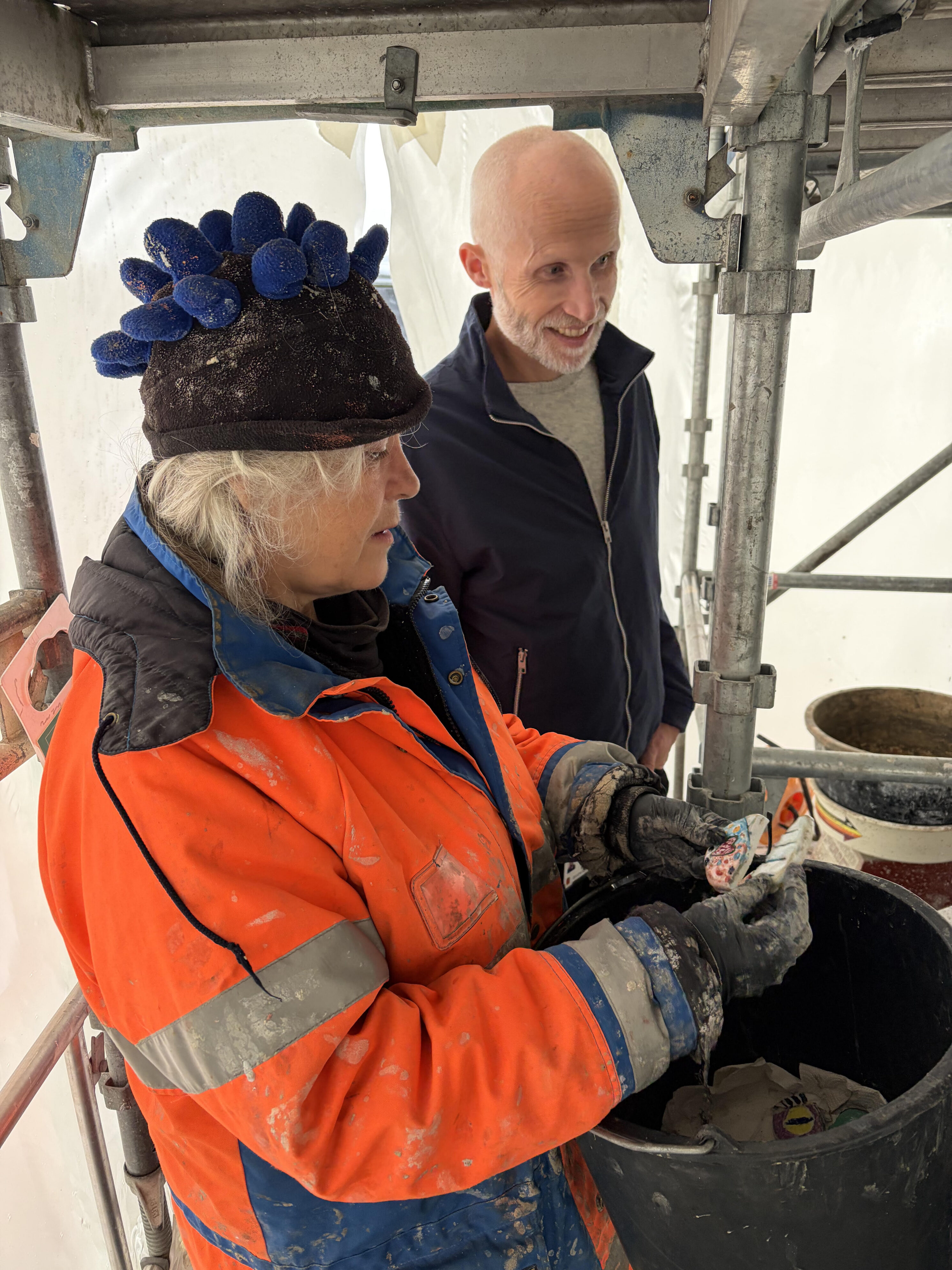 Marit Benthe Norheim viser Rune Jostein Eide øyne av porselen, som er laget av barn ved Skiens skoler.